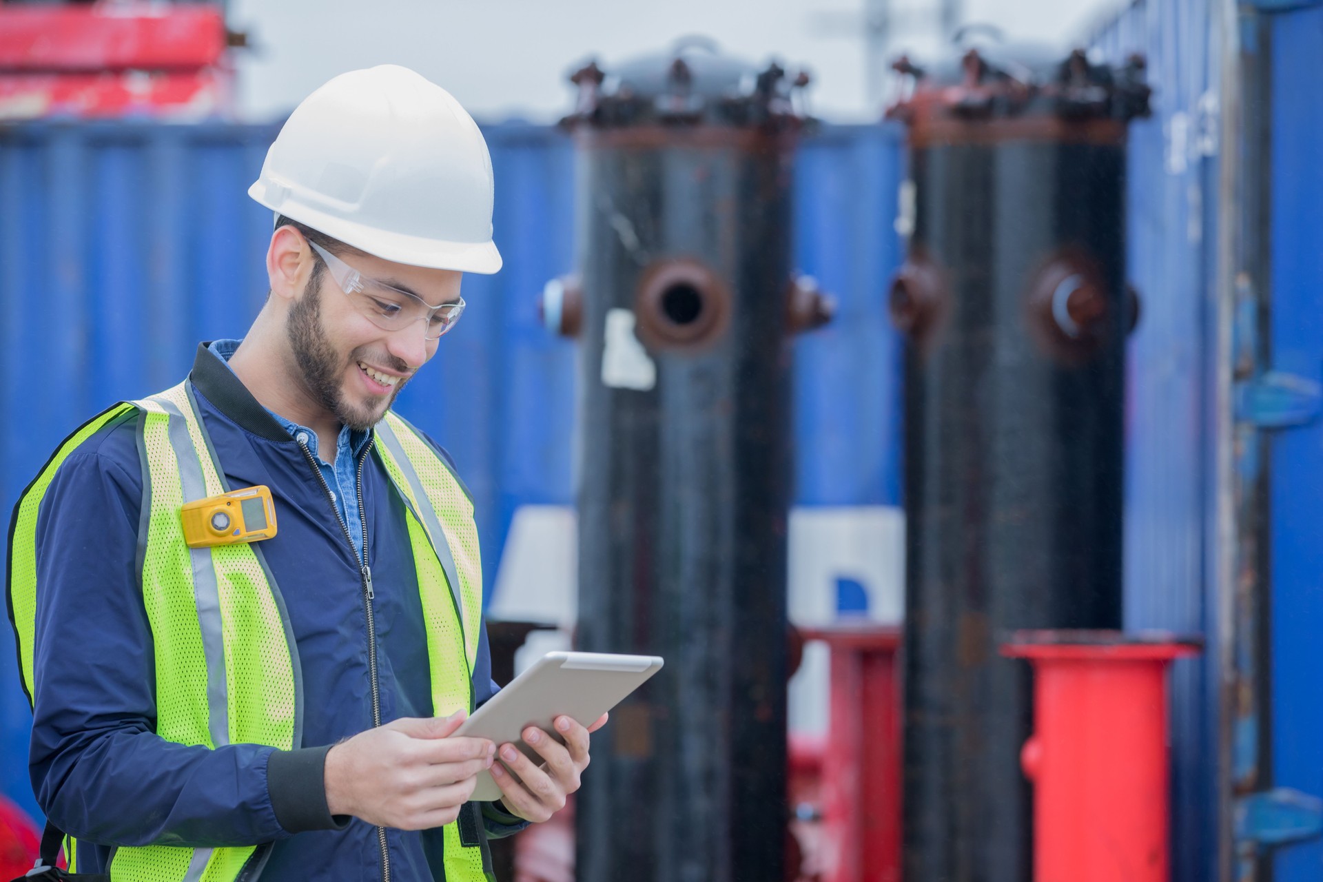 Ingeniero de tuberías usando la tableta digital mientras trabajaba en el lugar de trabajo de petróleo y gas